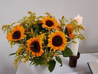 Sonnenblumenstrauß mit Kerze daneben